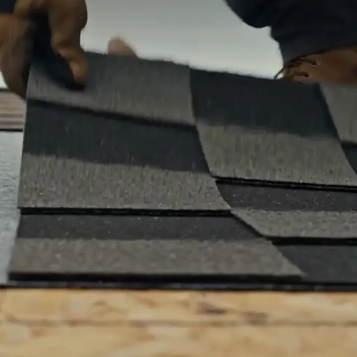 Close up of asphalt shingles being laid on a roof