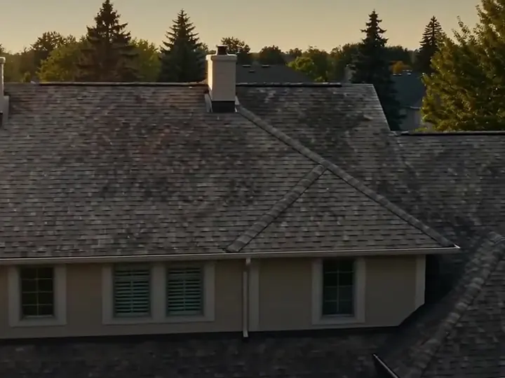 Worn, weathered shingles on a two storey house at dusk